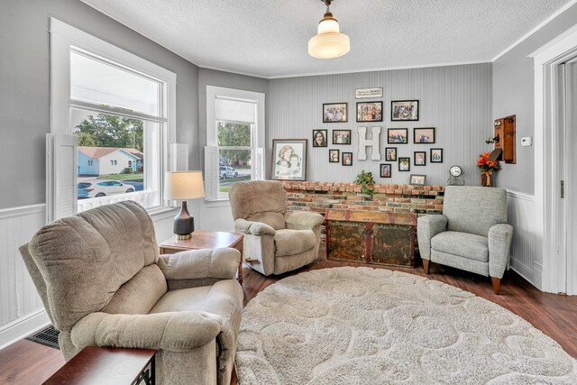 sitting room with a textured ceiling, crown molding, and dark hardwood / wood-style flooring