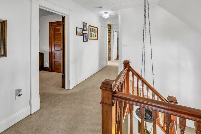 hallway featuring light colored carpet and vaulted ceiling