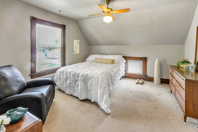 carpeted bedroom with multiple windows, lofted ceiling, and ceiling fan