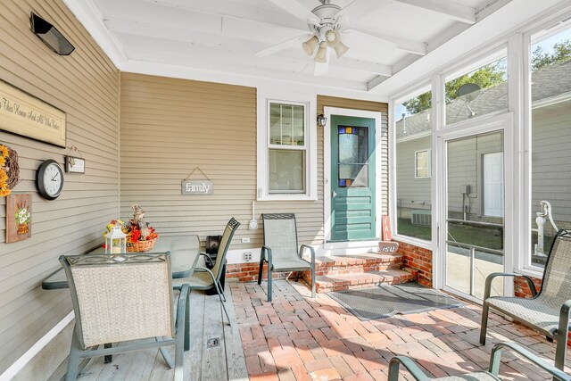 sunroom featuring beamed ceiling and ceiling fan