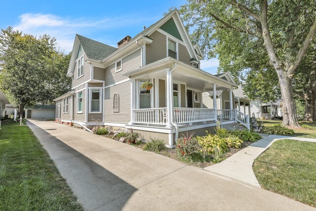 view of property exterior with a yard, a garage, and covered porch