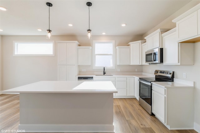 kitchen featuring a wealth of natural light, sink, a center island, and appliances with stainless steel finishes