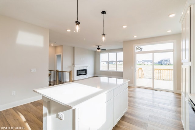 kitchen featuring a kitchen island, white cabinets, and light wood-type flooring