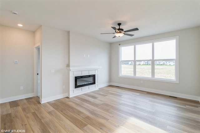 unfurnished living room with ceiling fan and light hardwood / wood-style flooring