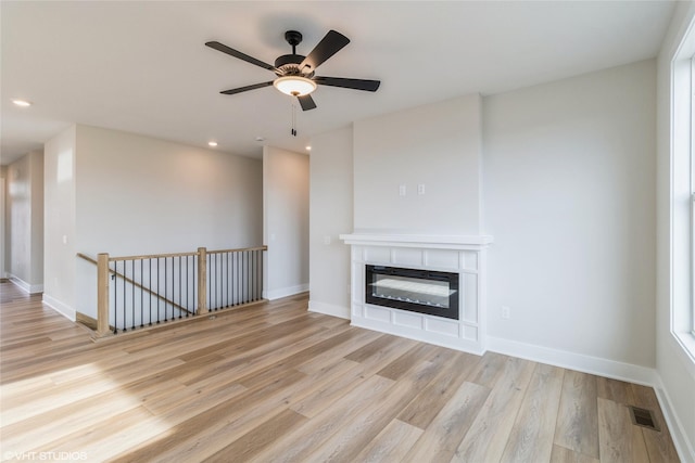 unfurnished living room with light hardwood / wood-style flooring and ceiling fan