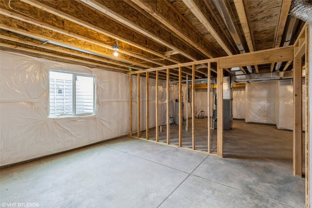 basement featuring gas water heater and heating unit