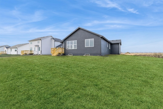 back of house featuring a lawn and a deck