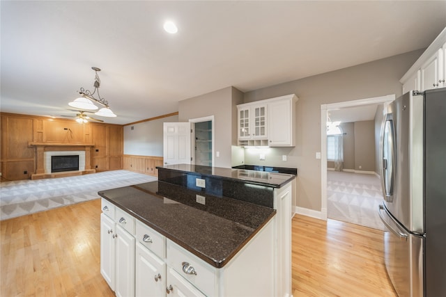 kitchen featuring white cabinets, a center island, stainless steel fridge, and light hardwood / wood-style floors