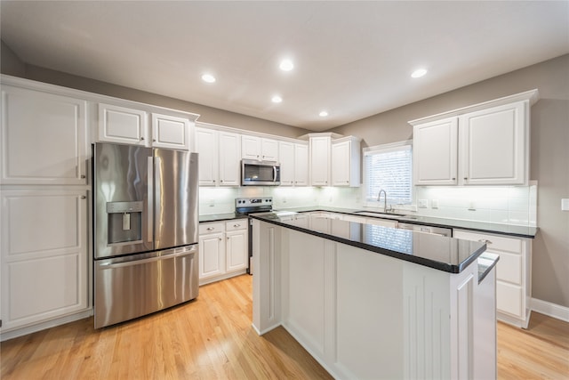 kitchen featuring sink, light hardwood / wood-style flooring, a kitchen island, white cabinetry, and stainless steel appliances