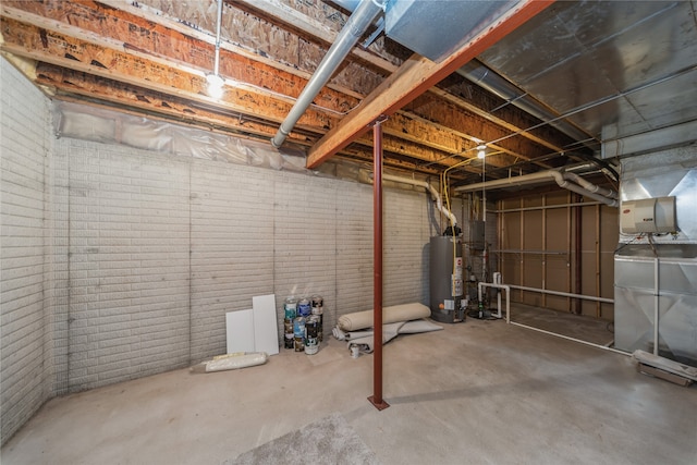 basement featuring brick wall and water heater