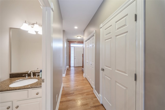 hall with sink and light wood-type flooring