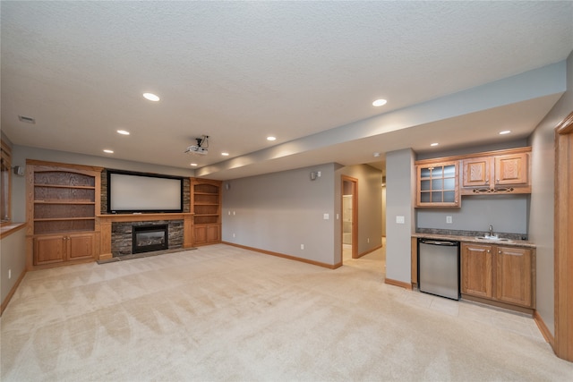 unfurnished living room with a stone fireplace, light carpet, a textured ceiling, and wet bar