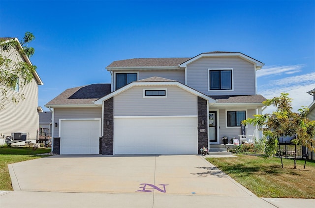 front of property featuring a garage, a front lawn, and central air condition unit