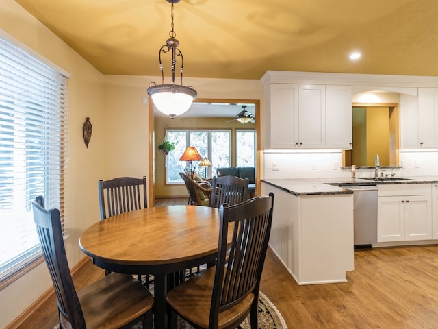 dining space featuring ceiling fan, light hardwood / wood-style flooring, and sink