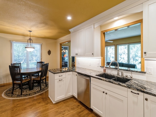 kitchen with white cabinets, dishwasher, and light hardwood / wood-style floors