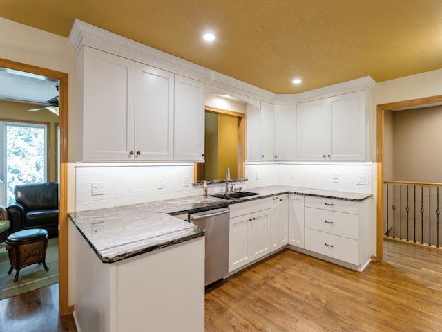 kitchen with white cabinets, light hardwood / wood-style floors, ceiling fan, and sink