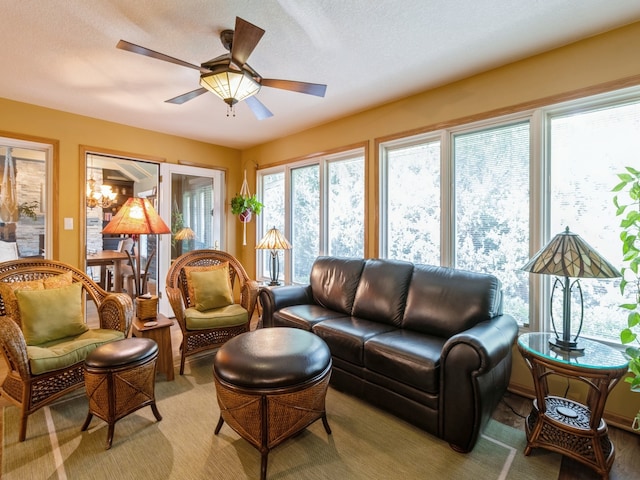 carpeted living room with ceiling fan and a textured ceiling