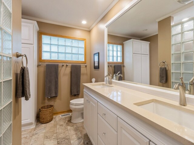 bathroom with crown molding, vanity, and toilet