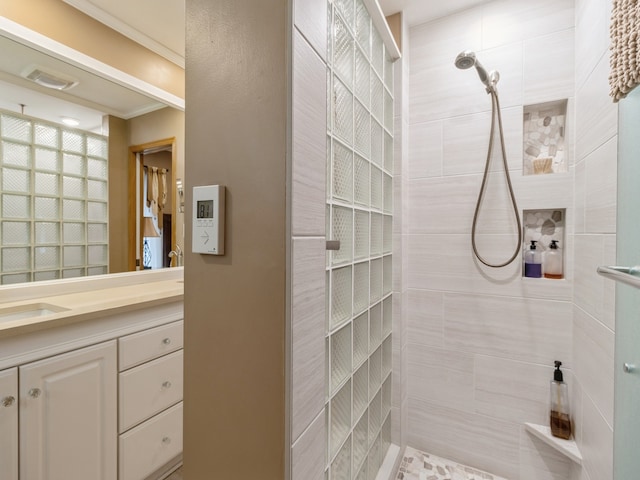 bathroom featuring a tile shower and vanity