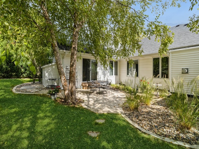 rear view of house with a yard and a patio area