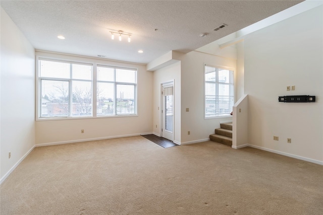 interior space featuring carpet flooring and a textured ceiling