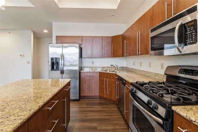 kitchen featuring light stone counters, sink, stainless steel appliances, and dark hardwood / wood-style floors