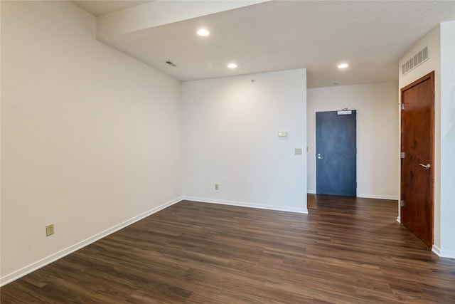 unfurnished room with a textured ceiling and dark hardwood / wood-style flooring