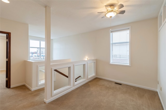 spare room featuring ceiling fan and light carpet