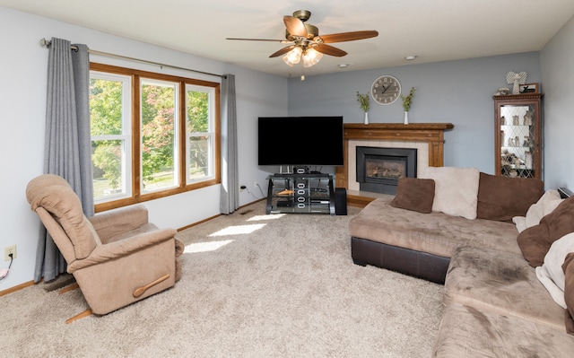 carpeted living room featuring a tiled fireplace and ceiling fan