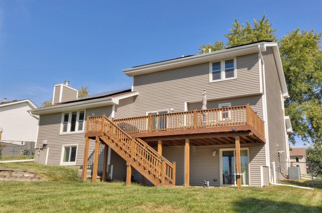 back of property featuring a wooden deck, central air condition unit, and a lawn