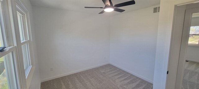 spare room with ceiling fan and light carpet