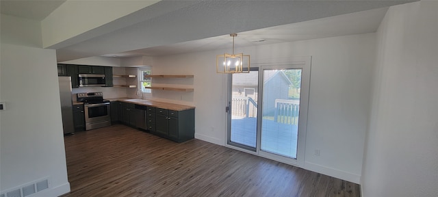 kitchen featuring dark hardwood / wood-style flooring, pendant lighting, stainless steel appliances, sink, and a notable chandelier