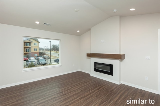 unfurnished living room featuring dark hardwood / wood-style floors and vaulted ceiling