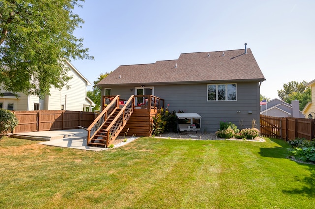 back of house with a lawn, a deck, and a patio