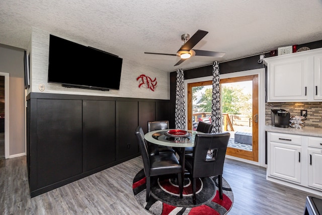 dining area featuring a textured ceiling, dark wood-type flooring, and ceiling fan