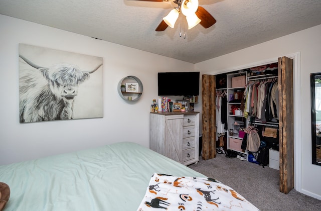 carpeted bedroom with ceiling fan, a textured ceiling, and a closet