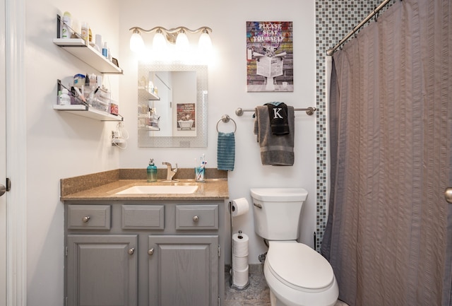 bathroom with curtained shower, vanity, and toilet