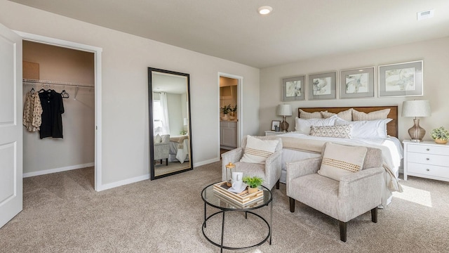 carpeted bedroom with a spacious closet and a closet