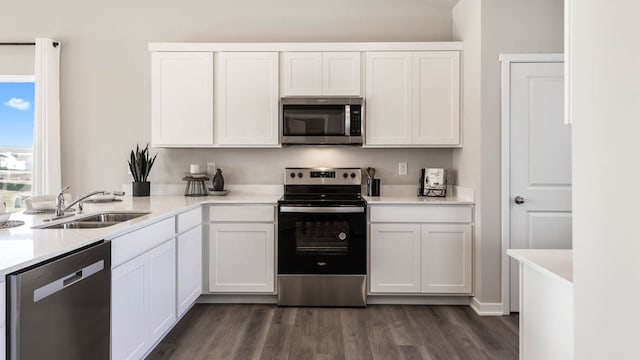 kitchen featuring white cabinetry, dark hardwood / wood-style flooring, sink, and appliances with stainless steel finishes