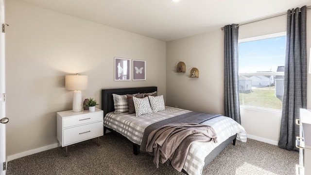 bedroom with dark colored carpet and multiple windows