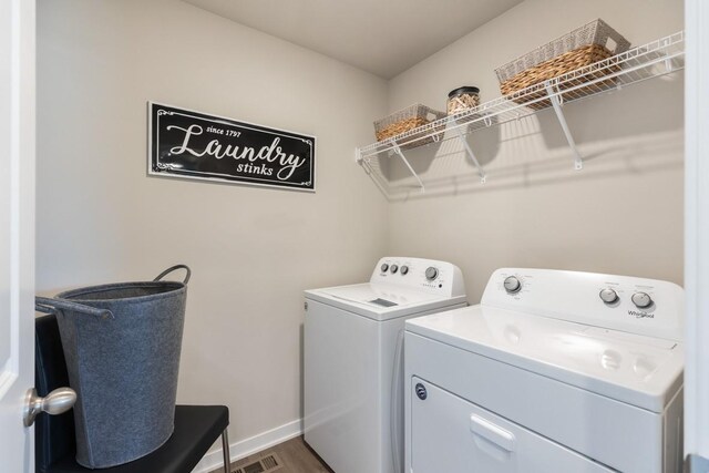 clothes washing area featuring washing machine and clothes dryer and dark wood-type flooring