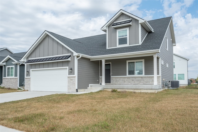 craftsman-style home with a front yard, a garage, a porch, and central AC unit