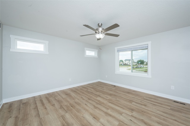 unfurnished room with ceiling fan, a textured ceiling, and light hardwood / wood-style flooring