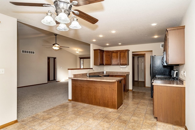 kitchen featuring lofted ceiling, sink, ceiling fan, light carpet, and kitchen peninsula