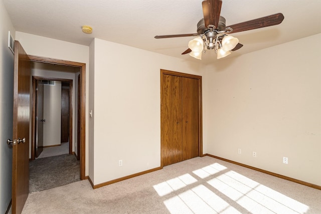 unfurnished bedroom with light carpet, ceiling fan, and a closet