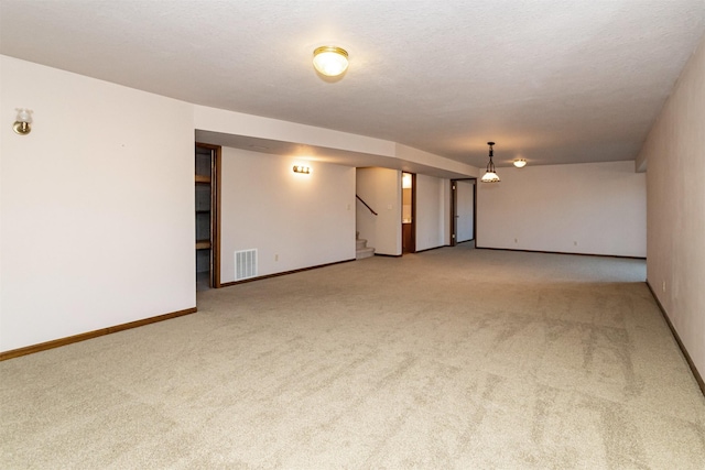 carpeted empty room featuring a textured ceiling