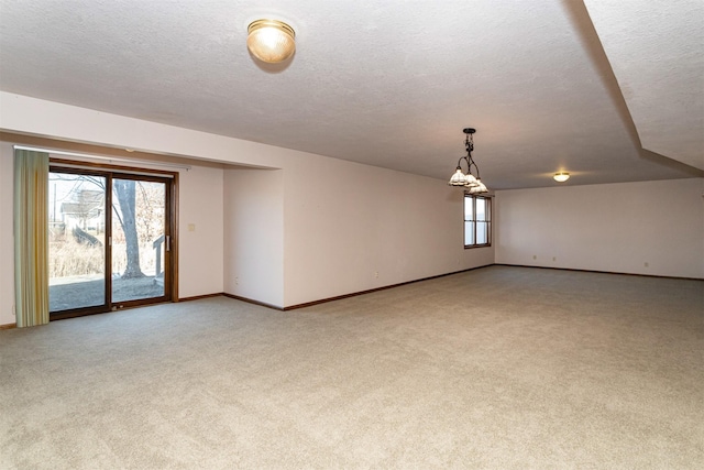 carpeted empty room featuring a textured ceiling