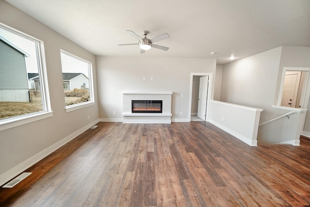 unfurnished living room with dark wood-type flooring and ceiling fan