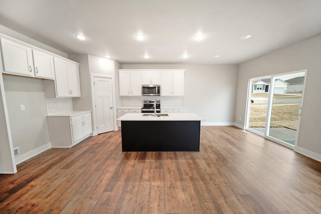 kitchen featuring stainless steel appliances, sink, an island with sink, and white cabinets