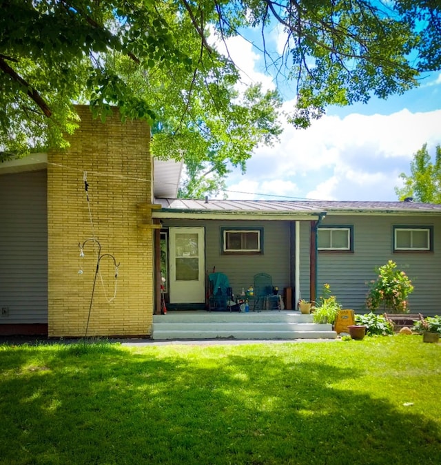 rear view of property with a yard